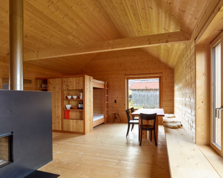 Der Wohnraum im Ferienhaus auf der Alp Flix ist komplett mit Holz verkleidet.